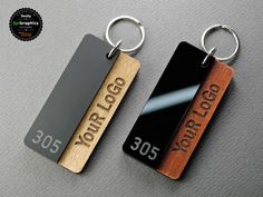 two wooden keychains with metal tags on them