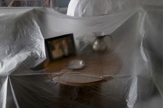 a table covered with white plastic and two silver spoons