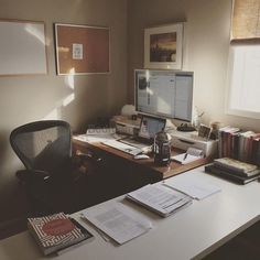 a desk with a computer, books and papers on it