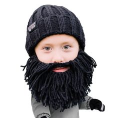 a little boy wearing a knitted hat with a long beard and black mittens