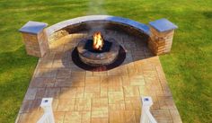 an outdoor fire pit surrounded by grass