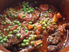 a stew with peas and carrots in a pot