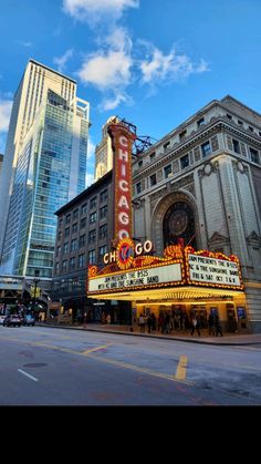 the chicago theater marquee is lit up in front of tall buildings and skyscrapers