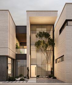 an exterior view of a modern building with trees in the courtyard