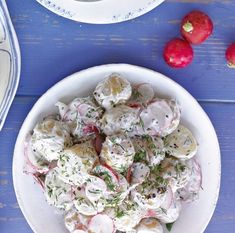 a white bowl filled with potato salad next to radishes