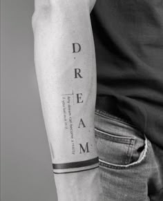 a man's arm with the word dream tattooed on it