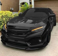 a black sports car parked in front of a house