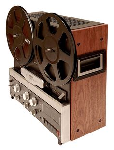 an old fashioned movie projector sitting on top of a wooden stand with two reels attached to it