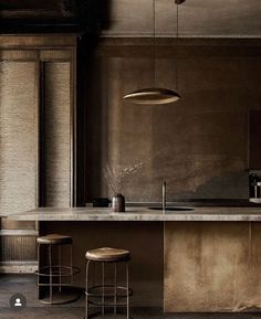 a kitchen with two stools next to a counter top and an island in the middle