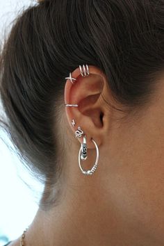 a close up of a person with ear piercings on their ears and behind them is a woman's head