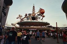 people are walking around in front of an amusement park