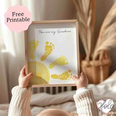 a baby holding up a framed print with the words, free printable you are my sunshine