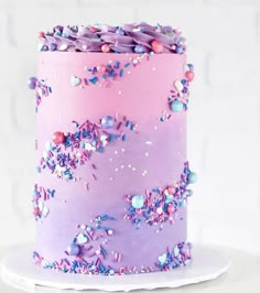 a pink and purple cake with sprinkles on it