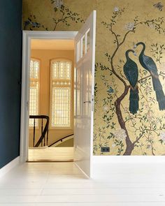 an open door leading to a room with wallpaper and paintings on the walls in it