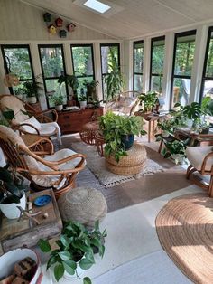 a sun room with wicker furniture and potted plants