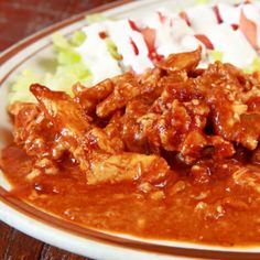 a white plate topped with meat covered in sauce