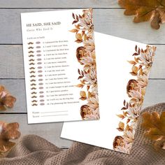 two white cards with gold foil flowers on them next to some brown and orange leaves