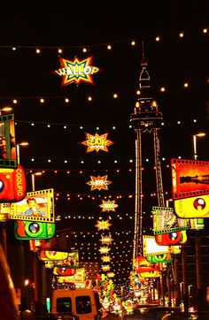 an image of a city street at night with christmas lights on the buildings and cars