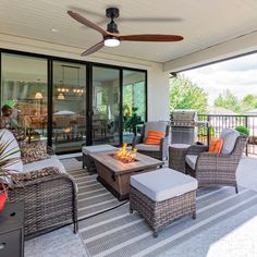 an outdoor living area with wicker furniture and a fire pit on the patio, surrounded by large sliding glass doors