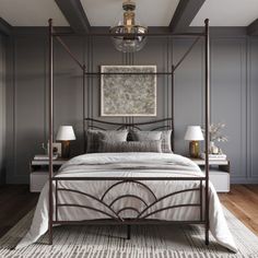 a bedroom with gray walls and white bedding has a chandelier hanging from the ceiling