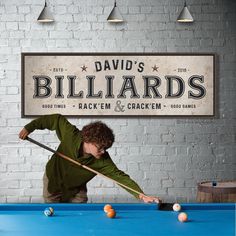 a young man playing pool in front of a sign that says billiard's