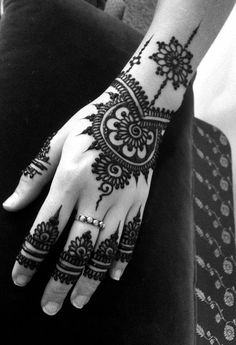 a woman's hand with henna tattoos on it