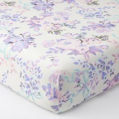 a white sheet with purple and blue flowers on it