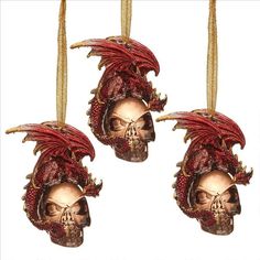 three skulls with red hair hanging from strings