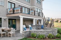 an outside patio with chairs and tables next to a house