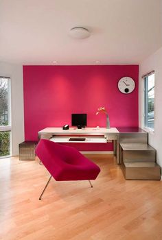 a pink chair sitting in front of a computer desk