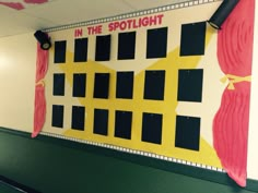 a bulletin board with red curtains and yellow stars on it that says in the spotlight