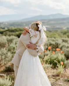 a bride and groom embracing each other in the desert