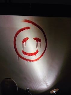 a red circle with the letter c in it on a white wall next to a lamp