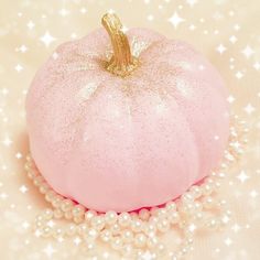 a pink pumpkin sitting on top of pearls