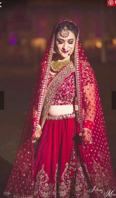 a woman in a red and gold bridal outfit