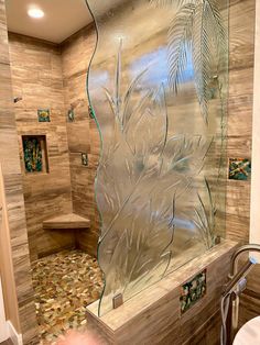 a glass shower door in a bathroom next to a toilet