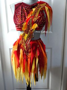 a mannequin dressed in red, yellow and orange costume with feathers on it