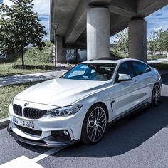 a white car is parked under a bridge