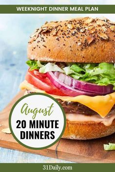 a large hamburger with lettuce, tomato and cheese on it next to a wooden cutting board