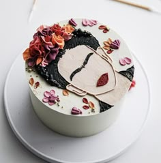 a decorated cake sitting on top of a white plate next to crochet needles