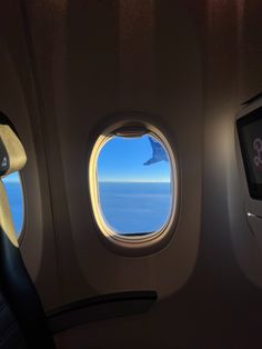 an airplane window looking out at the ocean