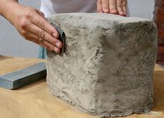 a person that is working on some kind of stone thing in the middle of a table