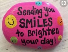 a pink painted rock that says sending you smiles to brighten your day