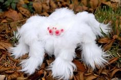 a white stuffed animal with red eyes laying on the ground