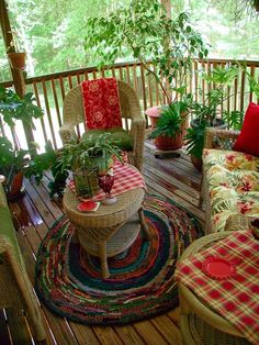 a porch with wicker furniture and potted plants on the table, along with rugs