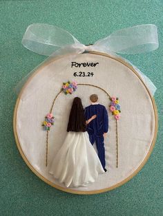 a cross stitch wedding ornament with a bride and groom holding hands under an arch