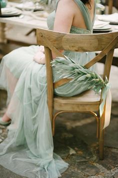 a woman sitting on top of a wooden chair