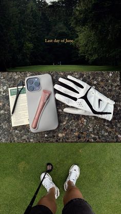 a pair of white shoes sitting on top of a grass covered field next to a phone case