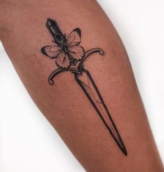 a tattoo with a butterfly on it and a knife in the shape of a flower