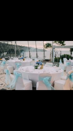 the tables are set with white linens and blue bows